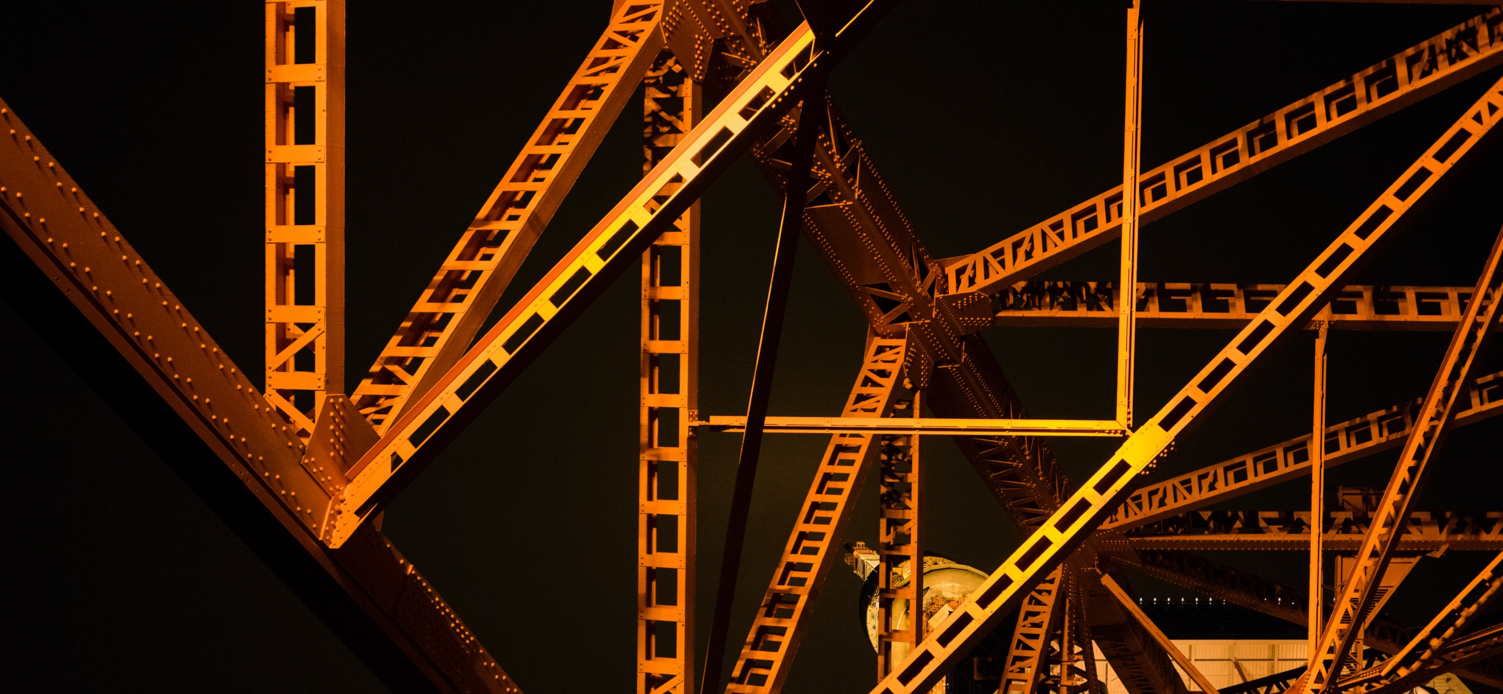 Illuminated steel beams showing the structure of a bridge